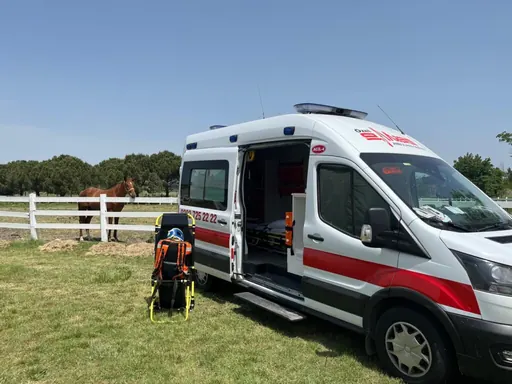 Açık hava etkinliğinde kapısı açık, ekipmanı hazır bekleyen ambulans